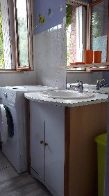 salle de bain avec machine a laver , seche linge et douche, 