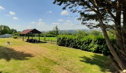 Jardin et salon sous kiosque, offrant une vue imprenable sur les vallées environnantes , Gîte Sous les deux arbres
